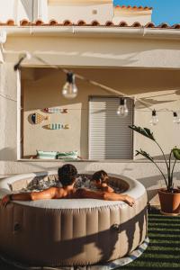 two men laying in a hot tub in a room at Casa Manjerico in Loulé