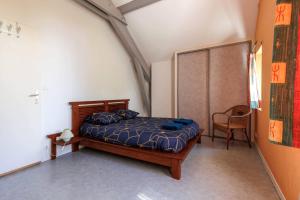 a bedroom with a bed and a chair in it at Villa Yantet - Conciergerieland in Soustons