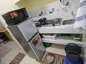 a small kitchen with a refrigerator and a sink at Favoured Brink in Nairobi