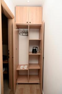 a kitchen with wooden shelves and a microwave at Elysium2 in Banja Luka