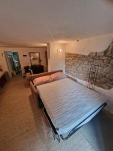 a bed in a room with a stone wall at Le Coccinelle in Pallerone