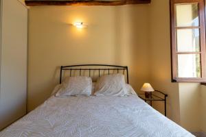 a bedroom with a bed with two pillows and a window at Maisonnette Chez Aurèle in Santa-Maria-di-Lota
