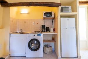 a kitchen with a washing machine and a refrigerator at Maisonnette Chez Aurèle in Santa-Maria-di-Lota