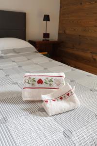 two towels sitting on top of a bed at Maison Rita e Cello in La Salle