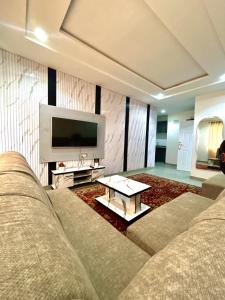a living room with a couch and a tv at Saint Apartment by Bento in Gwarinpa