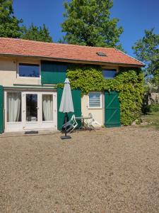 a green house with an umbrella in front of it at Gîtes de beaux rêves, Glycine in Uxeau