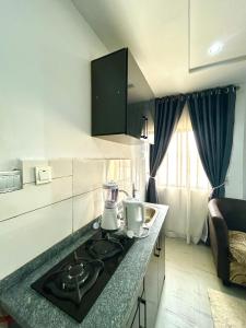 a kitchen with a stove and a counter top at Saint Apartment by Bento in Gwarinpa
