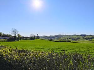 a green field with the sun in the sky at Gîtes de beaux rêves, Glycine in Uxeau