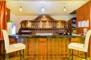 a bar in a restaurant with two white chairs at Pentagon Next Bhubaneswar in Bhubaneshwar