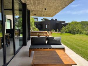 an outdoor patio with a couch and a table at Casa Cortaderas, Barrio Quequén Chico in Necochea