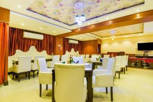 a dining room with white chairs and a dining table at Pentagon Next Bhubaneswar in Bhubaneshwar