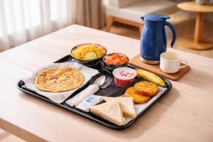 a black tray with food on a table at Hotel Golden Oasis - 5 Minute Walk from New Delhi Railway Station in New Delhi