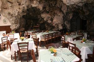 a restaurant with tables and chairs in a cave at Agriturismo La Grotta in Corbara