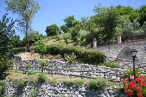 a stone retaining wall with flowers and a street light at Agriturismo La Grotta in Corbara