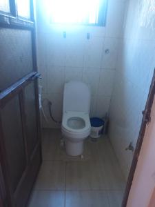 a small bathroom with a toilet in a stall at Cae Cozy Home in Karatu +4 photos