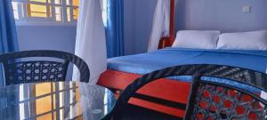 a bedroom with a bed and a table and chairs at Summer Oasis in Kitui