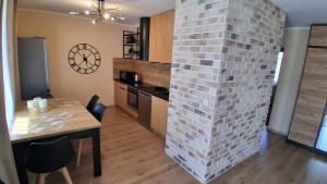 a kitchen with a brick wall next to a table at Umińskiego Spacious Apartment in Poznań