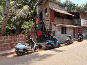 a row of scooters parked in front of a building at Datta Swami Homestay in Malvan