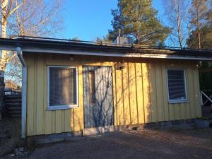 a yellow house with a door and two windows at Saunamökki in Helsinki