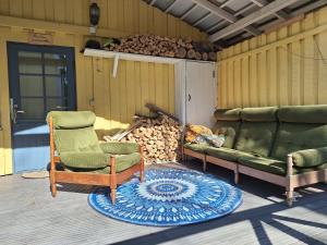 a patio with two chairs and a couch and a rug at Saunamökki in Helsinki