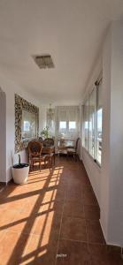 a living room with a table and chairs and a window at Three Horizons Penthouse El Saler in Valencia +9 photos