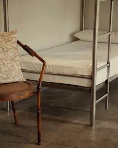 a bed and a chair next to a bunk bed at Casa Carmina Hostel in Muros de Nalón