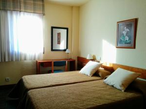 Giường trong phòng chung tại Apartamentos MultiBaqueira