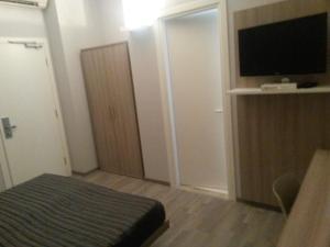 a small bedroom with a bed and a flat screen tv at Hotel Meuble' Atlantic in Treviglio