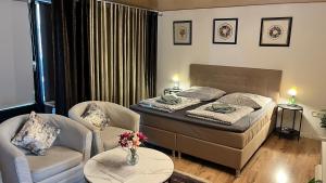 a bedroom with a bed and two chairs and a table at Private Studio Apartment with Balcony in Dortmund-Brackel in Dortmund