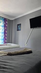 a bedroom with two beds and a flat screen tv on the wall at Mermaid house in Drama