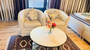 a living room with two chairs and a table with a vase of flowers at Private Studio Apartment with Balcony in Dortmund-Brackel in Dortmund