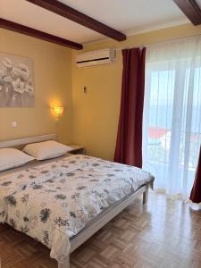 a bedroom with a bed and a large window at Guest house Ivo in Lovran