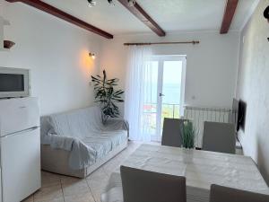 a living room with a table and a couch at Guest house Ivo in Lovran
