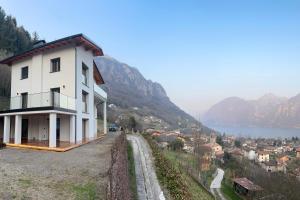 a house on a hill next to a body of water at Lake Retreat in Anfo