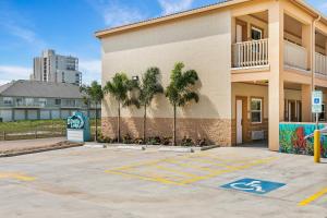 a building with palm trees in a parking lot at El Delfín Lodge in South Padre Island