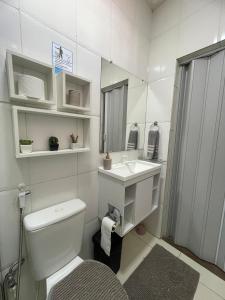 ein Badezimmer mit Toilette, Waschbecken und Spiegel in der Unterkunft Apto do Xavier in Juazeiro
