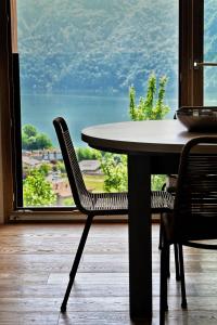 a table and chairs in front of a large window at Lake Retreat in Anfo