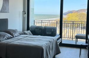 a bedroom with a bed and a balcony with a view at Baltic Infinity Suite 314 - SPA & Pool Access in Międzyzdroje +95 photos