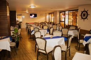 a dining room with tables and chairs and a tv at Clarion Hotel Nairobi in Nairobi