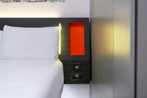a bedroom with a bed with a red light on the wall at easyHotel Sheffield in Sheffield +30 photos