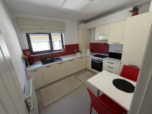 a kitchen with white cabinets and a table and a window at Biby apartament in Cluj-Napoca