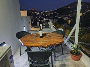 a wooden table with wine glasses on a balcony at Kanari Holiday Home in Gourna