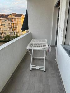 a small white table on the balcony of a building at Azure Pine Apartament in Golem