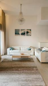 a living room with two white couches and a chandelier at Villa Morion with Sauna and Pool in Donji Morinj +123 photos