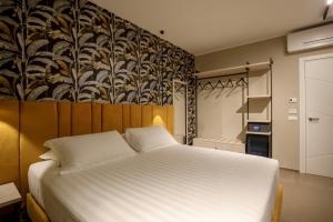 a bedroom with a large white bed and a wall at Fly Suite Rome Airport in Fiumicino