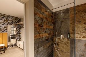 a bathroom with a brick wall and a shower at Fly Suite Rome Airport in Fiumicino