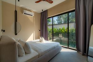 a bedroom with a bed and a large window at Demaya Villa 5 in Ko Phangan +39 photos
