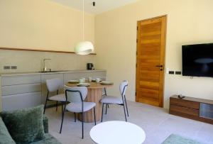 a living room with a table and chairs and a kitchen at Demaya Villa 5 in Ko Phangan