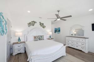 a white bedroom with a white bed and two dressers at Perfect location Pool 4 bedroom SGI Pet in Eastpoint