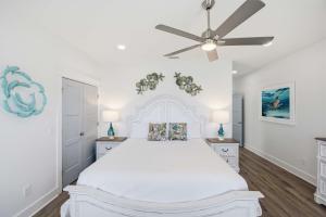 a white bedroom with a bed and a ceiling fan at Perfect location Pool 4 bedroom SGI Pet in Eastpoint